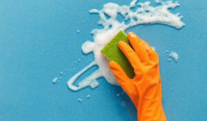 gloved hand with sponge wiping foam